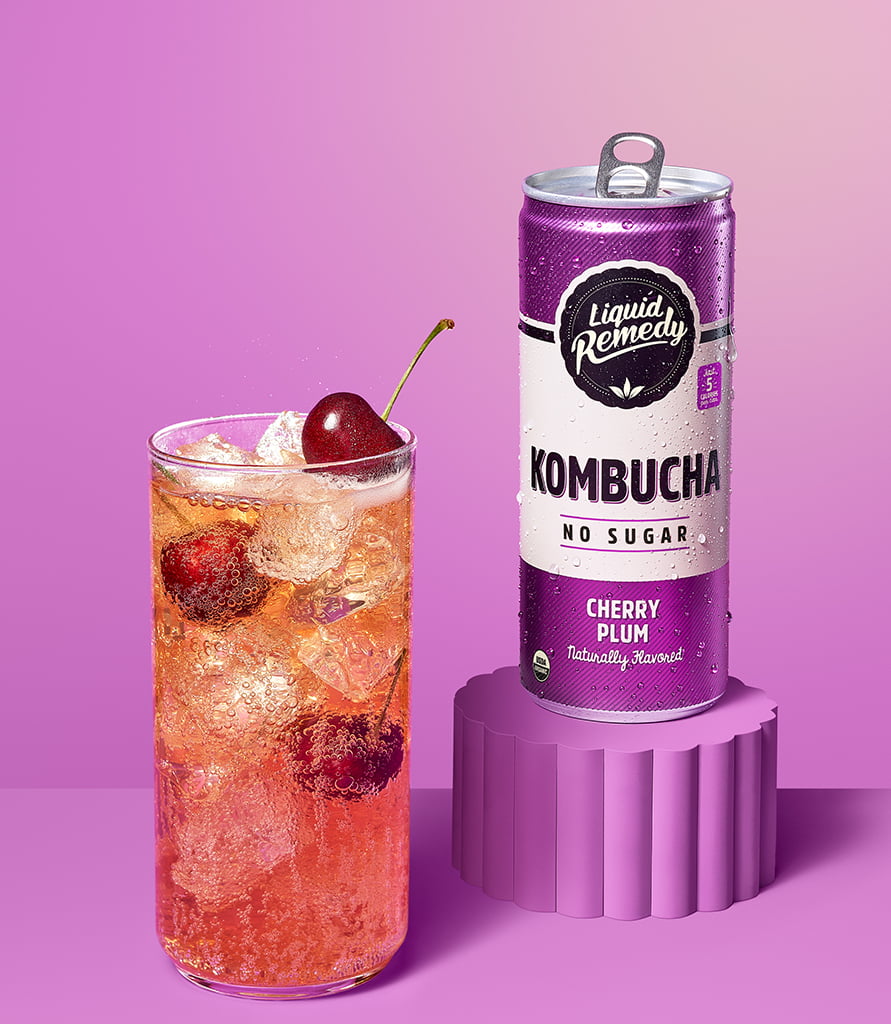 Liquid Remedy Cherry Plum Kombucha Can with Glass Lifestyle